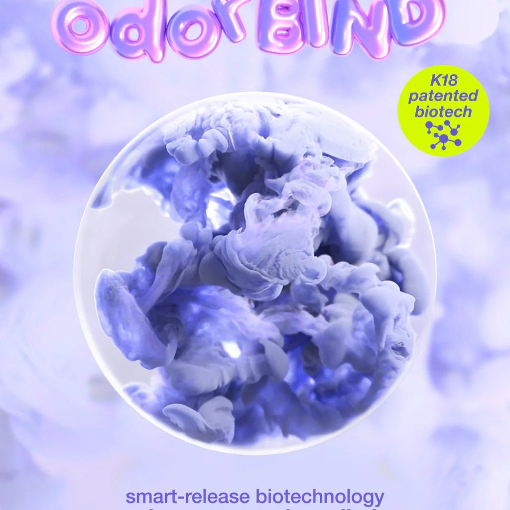A promotional poster for "K18 AirWash Dry Shampoo" featuring K18 patented biotech from Simply Colour Hair Salon Studio & Online Store. Text highlights odorBIND biotechnology that recognizes, suspends, and eliminates odors for 3 days. Background shows a purple abstract design. The product also functions as a dry shampoo that reduces oil in your hair.