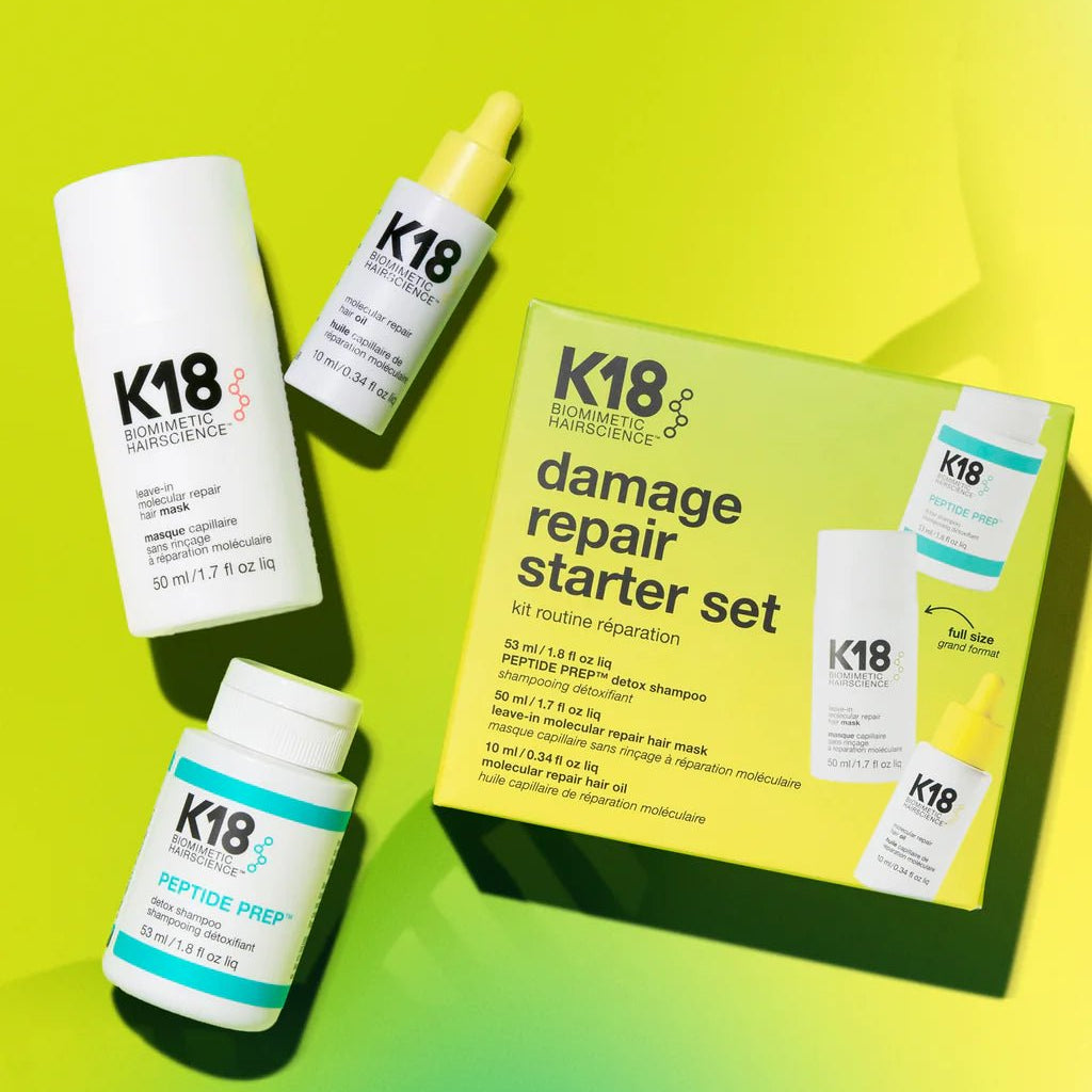 Image of K18 Hair Repair products against a gradient yellow-green background, featuring the K18 Damage Repair Starter Set, including a bottle of leave-in molecular repair hair mask, a bottle of peptide prep shampoo, and a bottle of hair oil. These vegan products harness the power of K18Peptide to reverse damage effectively.