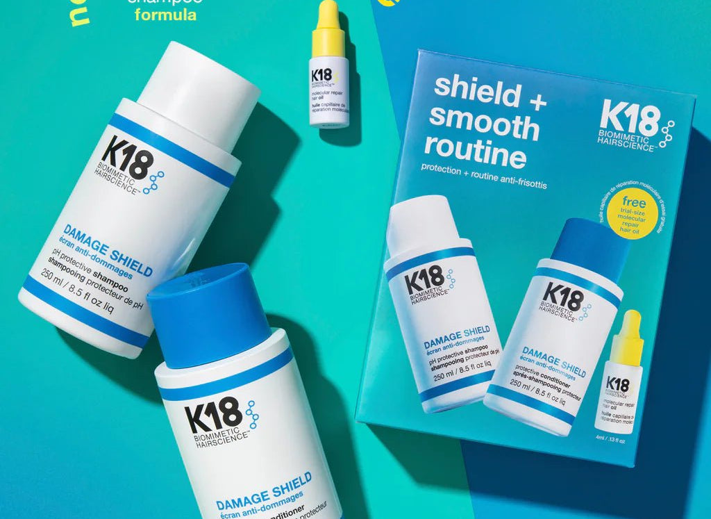 Collection of K18 Hair Repair products including Damage Shield protective shampoo, a small bottle labeled "new name! same pH maintenance shampoo formula", and the K18 Shield + Smooth Routine Set for frizz control.