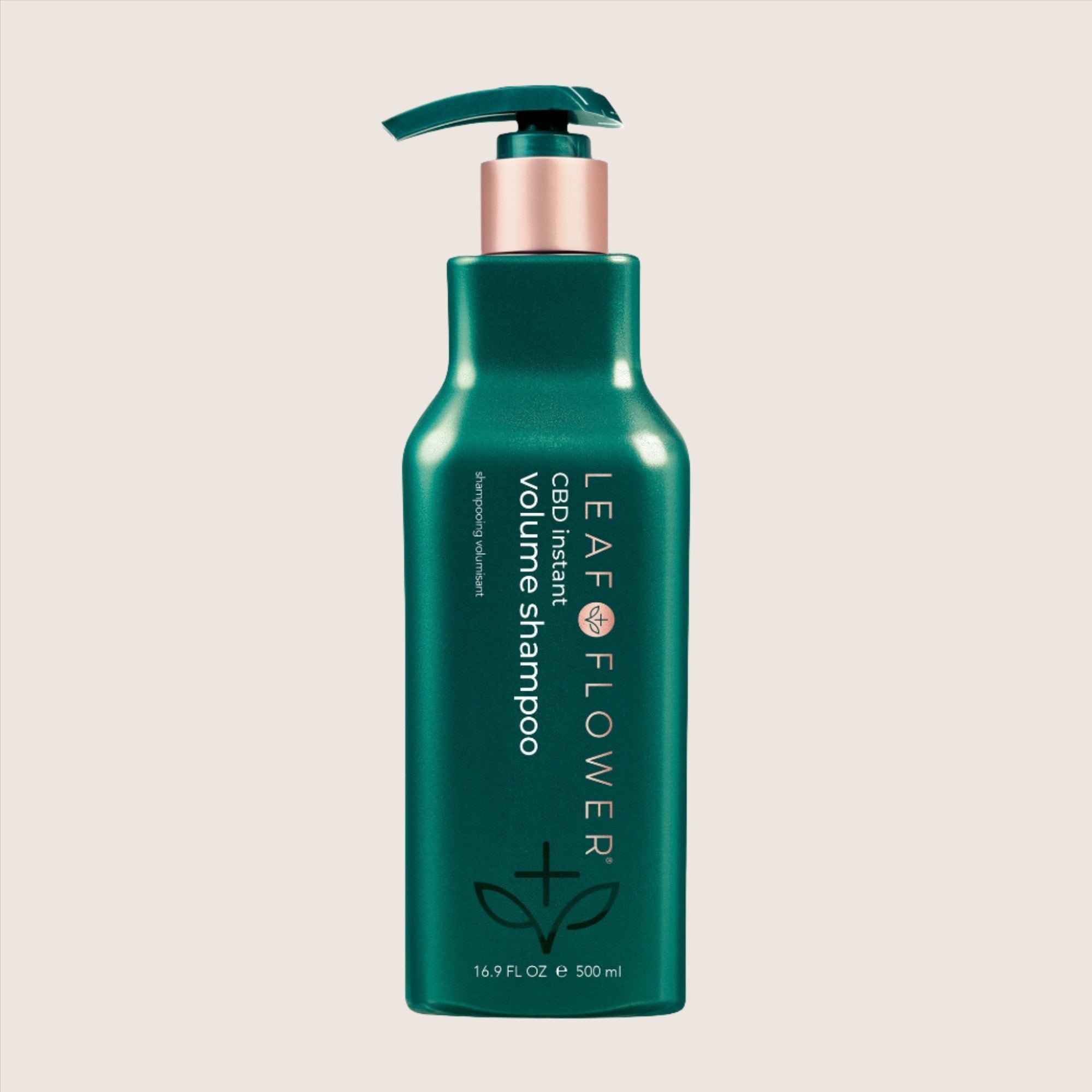A green 16.9 fl oz bottle of LEAF and FLOWER Instant Volume Shampoo, CBD-infused and plant-based, featuring a convenient pump top.