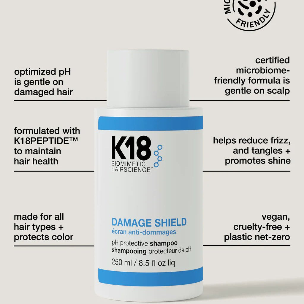 A bottle of K18 DAMAGE SHIELD pH Protective Shampoo - Multiple Sizes by K18 Hair Repair is shown. The label highlights features such as optimized pH, K18PEPTIDE™, microbiome-friendly formula, daily use, frizz reduction, shine enhancement, and vegan, cruelty-free status.